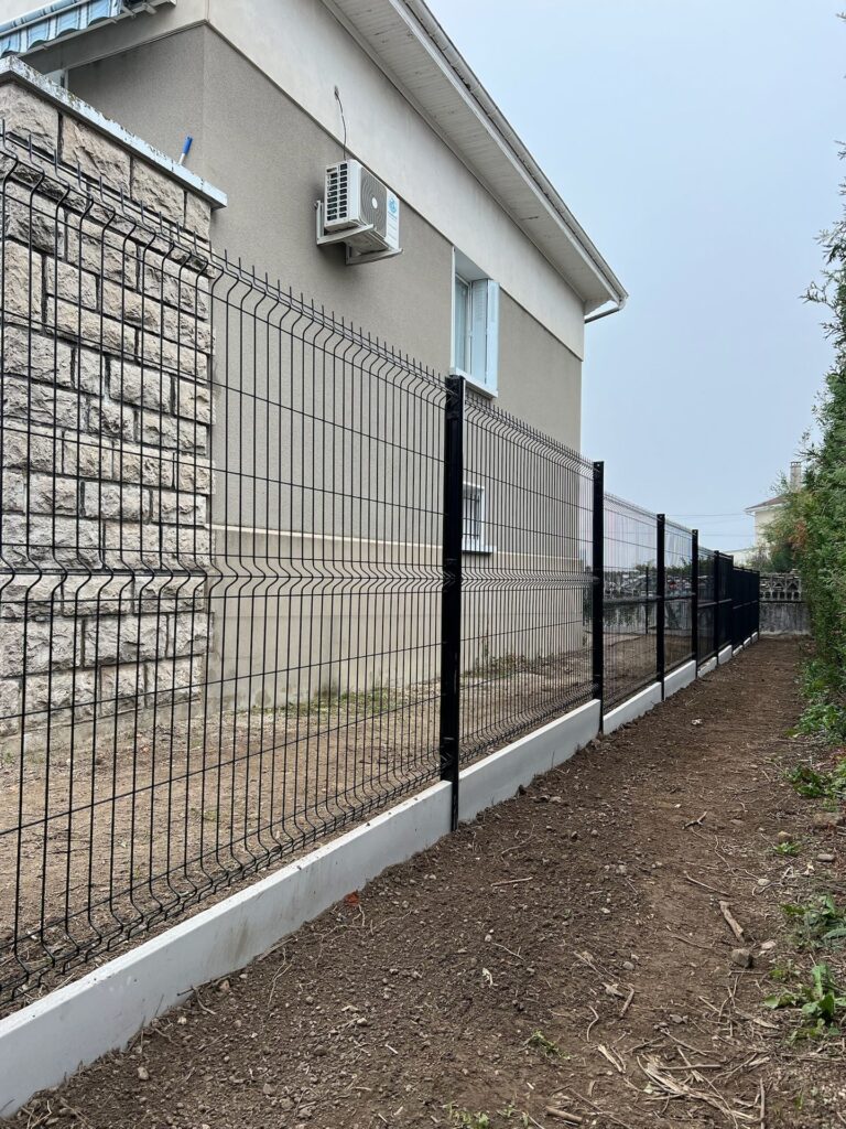Clôture en panneaux rigides le long d’une maison